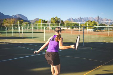 Bir parlak güneş ışığı altında bir kortta tenis oynuyor tenis oyuncu görüntüsünü kapatmak