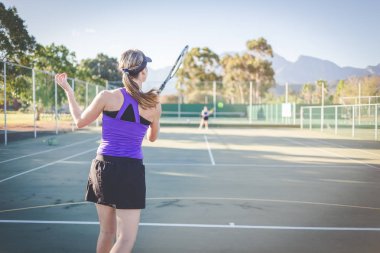 Bir parlak güneş ışığı altında bir kortta tenis oynuyor tenis oyuncu görüntüsünü kapatmak