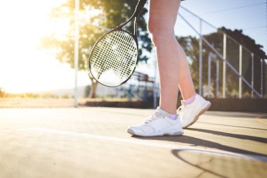 Bir parlak güneş ışığı altında bir kortta tenis oynuyor tenis oyuncu görüntüsünü kapatmak