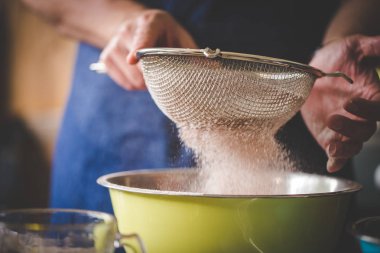Lezzetli bir pasta pişirmeye birlikte un ve maddeler eleme bir şef görüntü kadar kapatın.