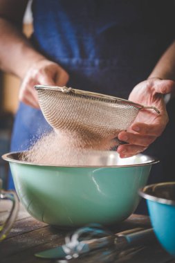 Lezzetli bir pasta pişirmeye birlikte un ve maddeler eleme bir şef görüntü kadar kapatın.