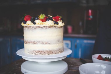 Krema ve çıplak bir pasta oluşturma ile bir havuç kek dekorasyon bir şef görüntüsünü kapatmak.