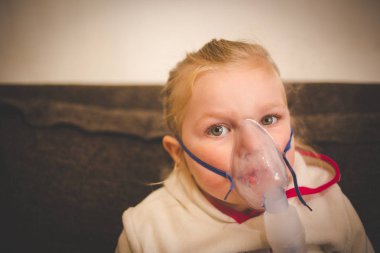 Göğüs hastalık temizlemek için tıp teneffüs edilmesi bir Nebulizatör, yürümeye başlayan çocuk kızla görüntüsünü kapatmak.