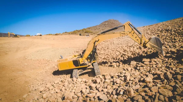 Μεγάλο Εκσκαφέας Σκάψιμο Έξω Αμμοχάλικο Και Πέτρες Μια Τοποθεσία Σκάβουν — Φωτογραφία Αρχείου