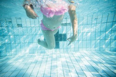 Geniş açı sualtı fotoğraf gözlük ve pembe bikini ile büyük bir yüzme havuzunda Yüzme bir yürümeye başlayan çocuk kız