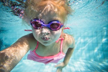 Geniş açı sualtı fotoğraf gözlük ve pembe bikini ile büyük bir yüzme havuzunda Yüzme bir yürümeye başlayan çocuk kız
