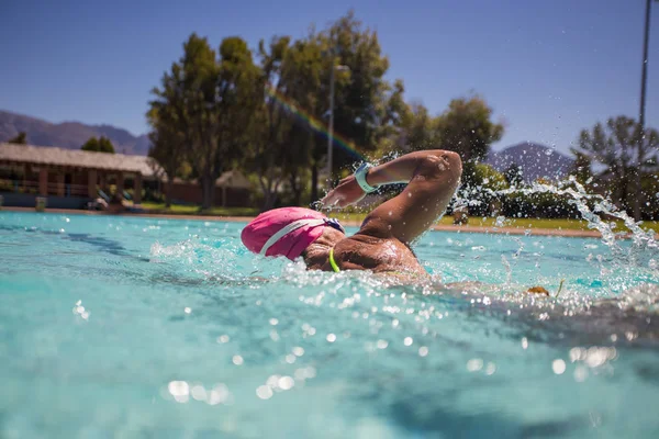 Close up wide angle photo of a female swimmer underwater in a swimming pool