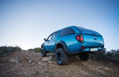 Modifiye edilmiş 4x4 pick up kamyonu almanın geniş açılı görüntüsünü doğada 4x4 pistte kapatın.