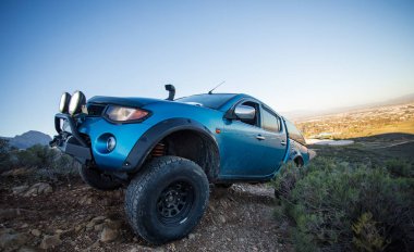 Modifiye edilmiş 4x4 pick up kamyonu almanın geniş açılı görüntüsünü doğada 4x4 pistte kapatın.