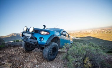 Modifiye edilmiş 4x4 pick up kamyonu almanın geniş açılı görüntüsünü doğada 4x4 pistte kapatın.