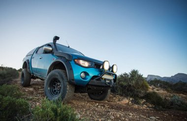 Modifiye edilmiş 4x4 pick up kamyonu almanın geniş açılı görüntüsünü doğada 4x4 pistte kapatın.