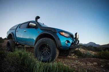 Modifiye edilmiş 4x4 pick up kamyonu almanın geniş açılı görüntüsünü doğada 4x4 pistte kapatın.