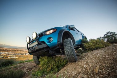 Modifiye edilmiş 4x4 pick up kamyonu almanın geniş açılı görüntüsünü doğada 4x4 pistte kapatın.