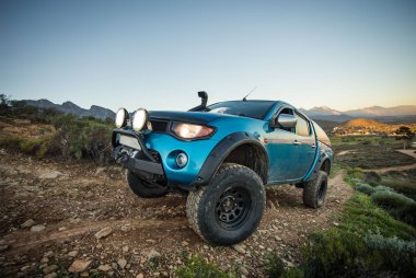 Modifiye edilmiş 4x4 pick up kamyonu almanın geniş açılı görüntüsünü doğada 4x4 pistte kapatın.