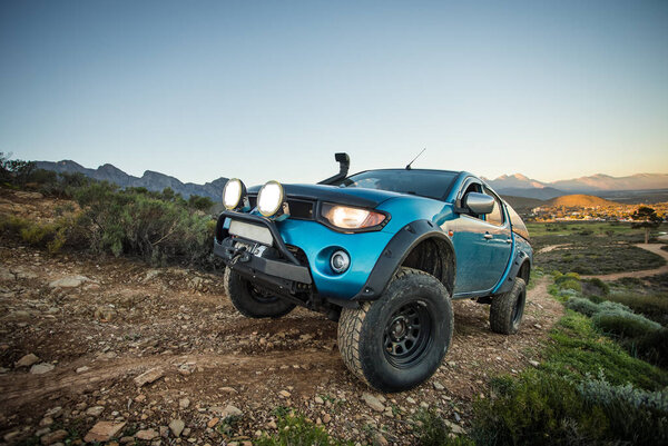 Крупный план широкоугольного изображения модифицированного пикапа 4x4, движущегося по природной дорожке 4x4
.