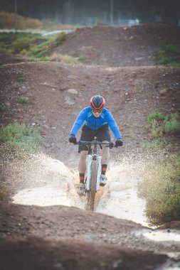 Bir dağ bisikletçisinin dağ bisikleti yolunda hızla giderken görüntüsünü kapatın.
