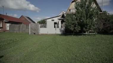 Bir adam evine geliyor. Bir adam köyde evin kapısına gider.