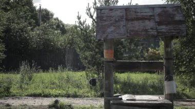 İki adam tarafından bir de köyde geçmek. Bir adamın bir tekne için bir yandan çarklı var. Diğeri bir çanta tutuyor.