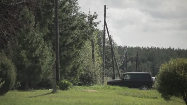 Μαύρο Αυτοκίνητο Βρίσκεται Στο Χωριό Ξύλινοι Πάσσαλοι Ηλεκτρικά Καλώδια — Αρχείο Βίντεο