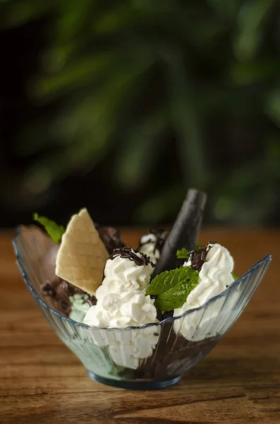chocolate and mint ice cream sundae dessert on wooden table