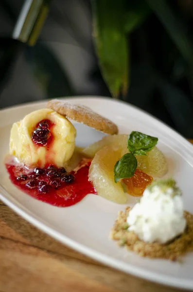 Gourmet mango ice cream with redcurrant sauce dessert on plate — Stock Photo, Image