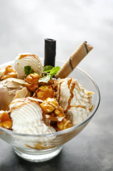 caramel and almond ice cream sundae dessert in glass bowl