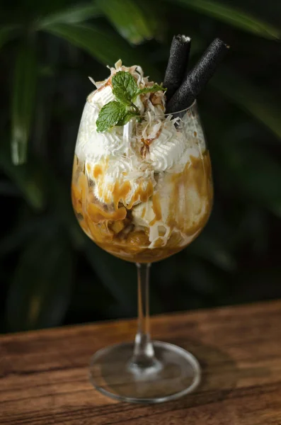 Coconut and caramel ice cream sundae dessert in wine glass — Stock Photo, Image