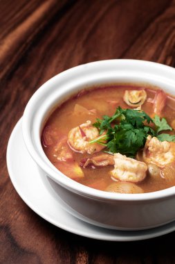 Thai Tom yum kung baharatlı ve ekşi karides çorbası ahşap masa arkasında phuket thailand