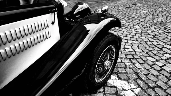 Front side part of vintage classic black hot rod car on a cobble road — Stock Photo, Image