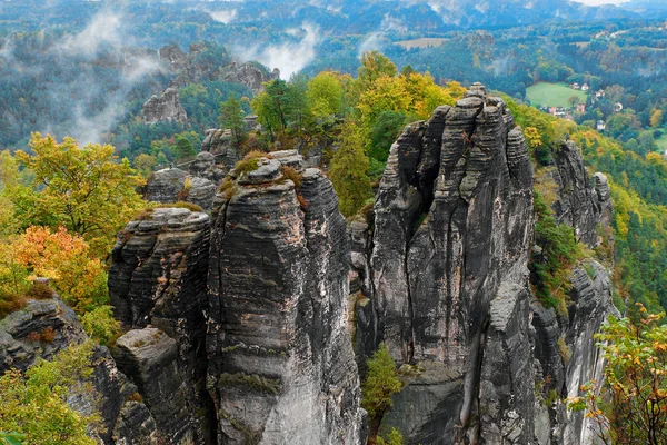 Vista rocosa de la montaña durante la temporada de otoño. Salida del sol brumosa en Bastei, Suiza sajona, Alemania —  Fotos de Stock