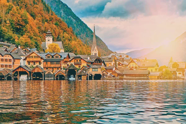 Hallstatt mountain resort med berömda kyrkan, traditionella Alperna byhus och landsbygdens träbåt hus vid sjön Hallstätter. Soluppgång över österrikiska Alperna bergen. Plats: Hallstatt, Österrike, Alperna — Stockfoto