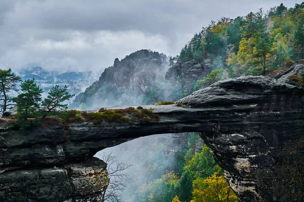 Pravcicka ゲート (Pravcicka brana) の霧霧風景スイス チェコ (ボヘミアのスイス連邦共和国またはチェスケー Svycarsko) 国立公園のヨーロッパで最大の自然な砂岩アーチします。 — ストック写真