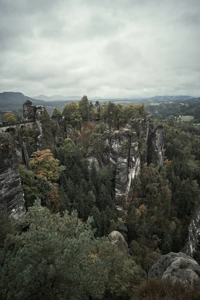 朝の霧は、ザクセン ・ スイスの国立公園で日の出山にザクセン ・ スイスのバスタイ、ドイツの視点から黒い霧霧山を無表情な — ストック写真