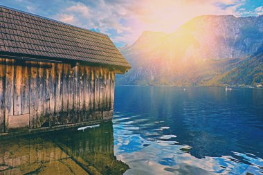 Avusturya Alplerinde göl üzerinde güzel doğal gün batımı. Hallstatt dağ köyü göle ahşap tekne evde Alpleri'nde. Yer: tatil köyü Hallstatt, Salzkammergut, Avusturya, Alpler. Soğuk tonda