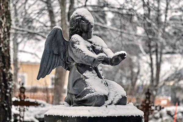 Bevroren engel bedekt met sneeuw op het kerkhof graf werf in de winter — Stockfoto