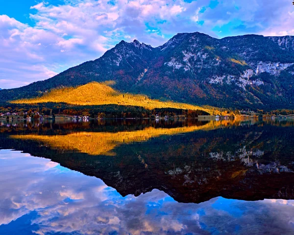 Avusturya Alplerinde gölde güzel doğal gün batımı. Eski vintage kırsal evleri ve Alpler Hallstatt dağ gölü mavi saatte evlerde ahşap tekne. Yer: tatil köyü Hallstatt, Avusturya, Alpler