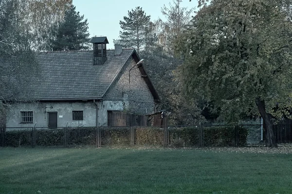 Altes Haus und Zaun mit Elektroleitungen im Konzentrationslager Auschwitz-Osventsim — Stockfoto