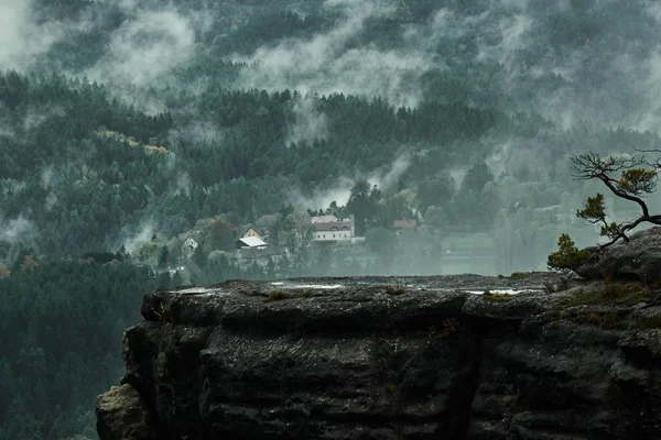 Tödliche dunkle neblige regnerische Morgenlandschaft mit den sandigen felsigen Bergen in der tschechischen Sächsischen Schweiz in herbstlichen Farben Stockbild