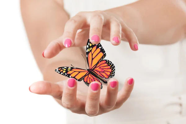 Twee handen van de vrouw bescherming vlinder met gele en oranje Colo — Stockfoto