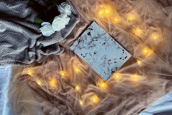 Parlak ışıklı romantik bir arka plan ve günlüklü tozlu bir gül.