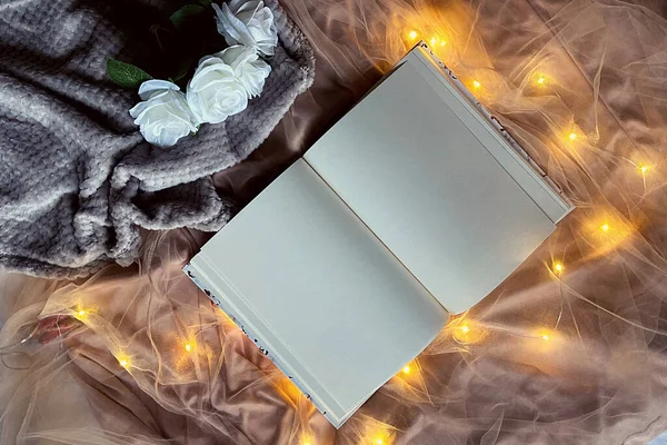 Parlak ışıklı romantik bir arka plan ve günlüklü tozlu bir gül.