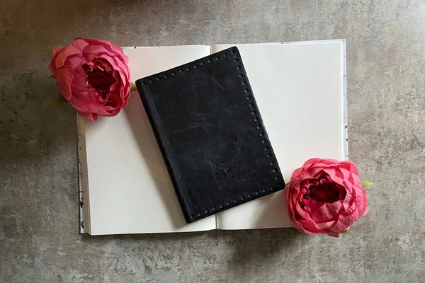 light and airy background with flowers and journal on concrete