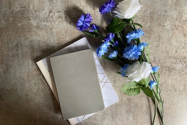 light and airy background with flowers and journal on concrete