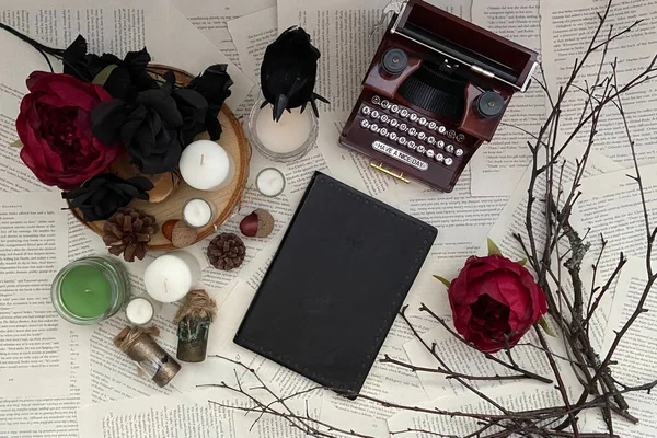 Gothic background with Fall aesthetic and twigs with flowers, candles, and blank book cover