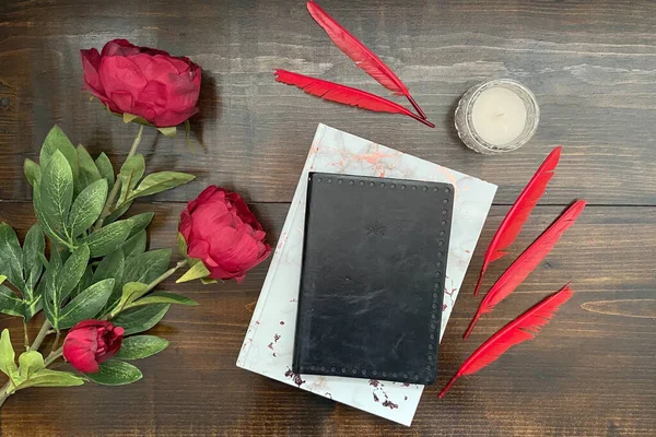 stock image wood background with black roses and red feathers and blank book