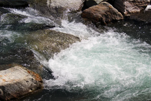 石で山の小川に泡で白く流れる水 — ストック写真