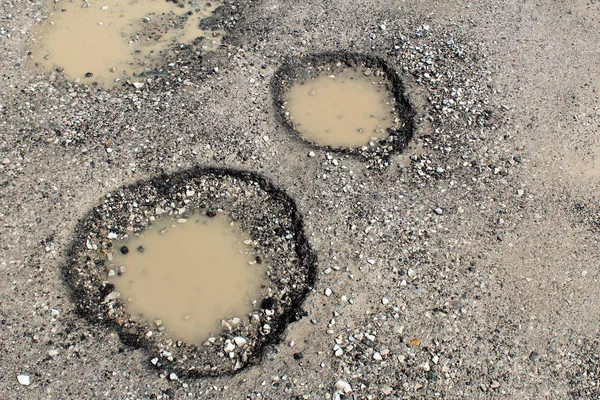 Potholes filled by water on a rural unpaved road