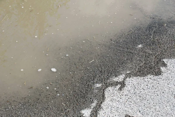 雨シャワー後のアスファルトの泥水 — ストック写真