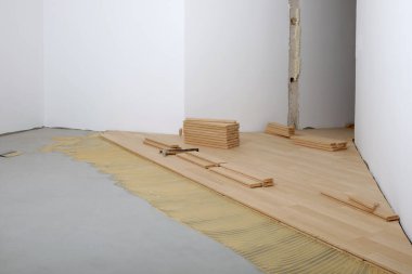 Parketin yenilenmiş bir oda kurulumunda inşaat. Pad parke için yapıştırıcı ile uygulanmış.