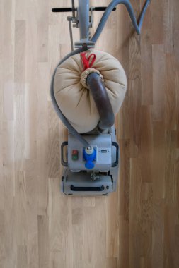 Öğütme makinesiyle ahşap zemini kazımak. Apartmanda tamirat var. Marangoz parke ahşap parke döşeme bakım işi yapıyor.